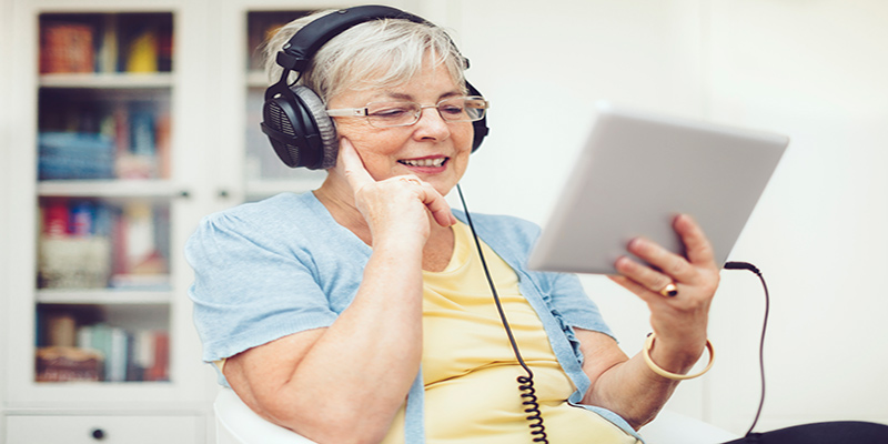 Senior Woman listening with Tablet